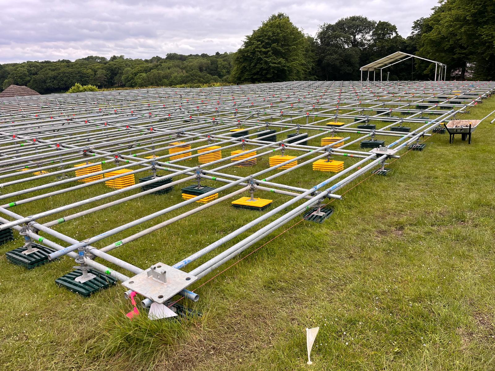 Galvanised scaffold grid laid out on grass as a marquee understructure